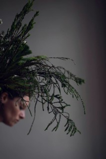 Head of woman behind ostrich with grasses