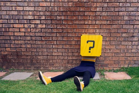 Body lying on a wall, question mark as head