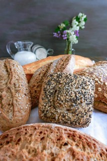 Freshly baked artisanal bread featuring various types and textures, displaying a rich culinary
