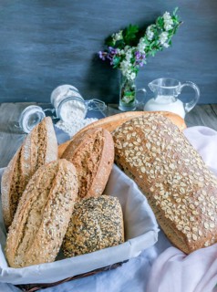 Freshly baked artisanal bread assortment displaying sourdough, multigrain, and seeded loaves and