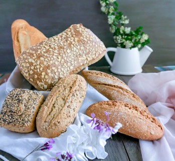 Various freshly baked artisanal bread loaves, including whole grain and sourdough, beautifully