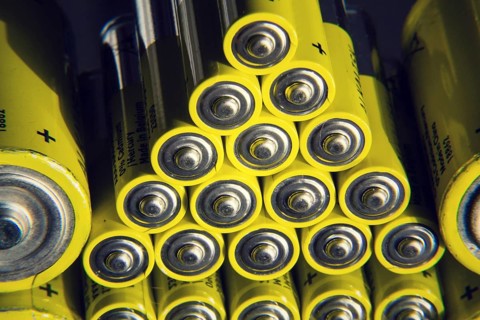 Yellow double A batteries reflecting in mirror, electricity storage concept
