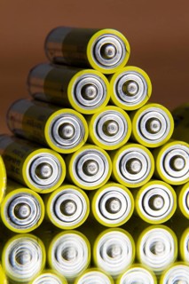 Stack of yellow AA batteries close up abstract coloured background