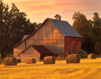 A barn in North Hero, Vermont with round bales of hay