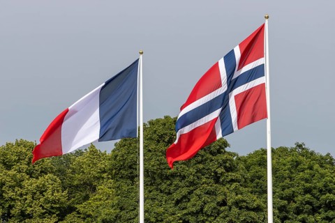 The national flag of Norway and the flag of France hoisted at the Palace Square in Oslo for the