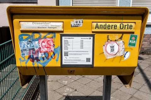 Painted and stickered post box in Mörsenbroich — Düsseldorf, North Rhine-Westphalia, Germany
