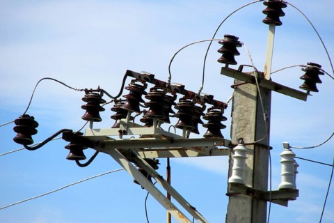 Electrical cables and ceramic, porcelain insulators of high voltage transmission line on top of