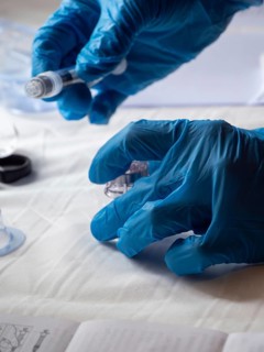 Stambul, Turkey October 21st 2025 Hands in blue gloves preparing a syringe and medication for
