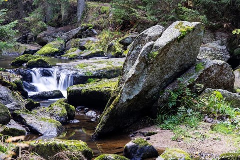 A stream flows over large, moss-covered stones and creates a peaceful atmosphere, Höllfall