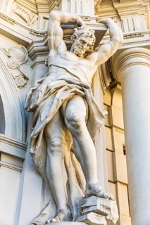 Marble statue as a support on a historic building of the Kinski auction house, Vienna, Austria