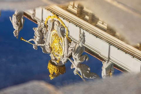 Angel statues on the roof of the Hofburg Imperial Palace are reflected in a waterhole, Vienna,