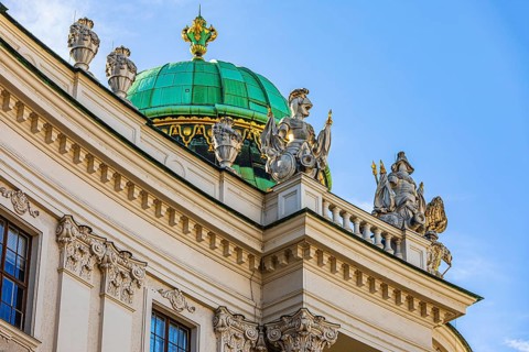 Dome with pompous figures on the roof of the Hofburg Imperial Palace, Vienna, Austria