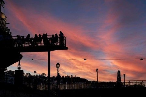 Visitors sit at sunset on the terrace of a cafe in the Urania am Danube Canal, Urania Observatory,