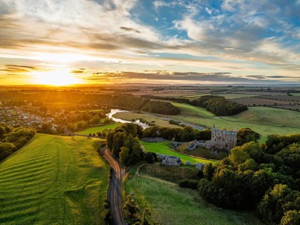 Sunset over Norham Castle and River Tweed from a drone, Norham, Northumberland, England, United
