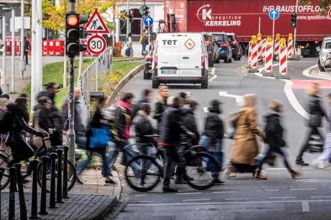 Pedestrians at Düsseldorf-Bilk train station, cross Friedrichstraße at a pedestrian crossing with