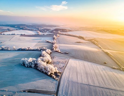 Bird Eye Perspective of Frost Covered Farmland. Seasonal Agricultural Scenery, winter and autumn