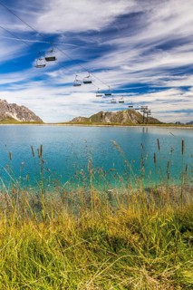 The panoramic lake on Saloberkopf with cable car and mountains in the background under a blue sky,