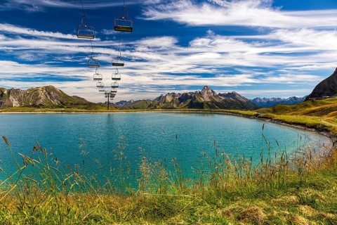 The panoramic lake on Saloberkopf with cable car and mountains in the background under a blue sky,