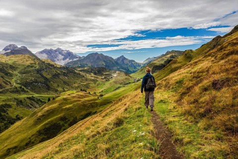 A hiker on a narrow path in the middle of a picturesque mountain landscape, Schröcken, Austria