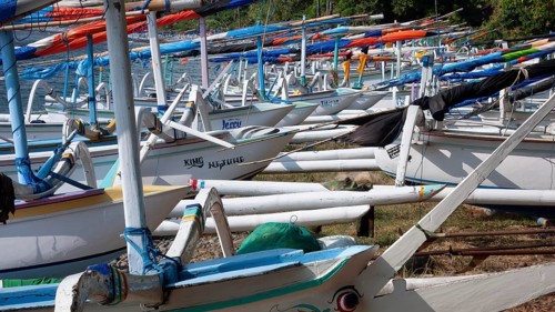 Close-up view of many local small fishing boats outrigger boats on the beach of sea bay near Amed,