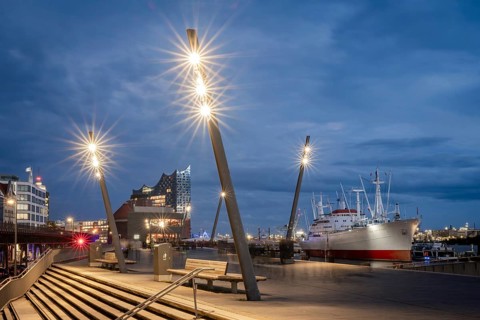 Blue hour at Hamburg Landungsbrücken with Elbe Philharmonic Hall, Cap San Diego ship and shining