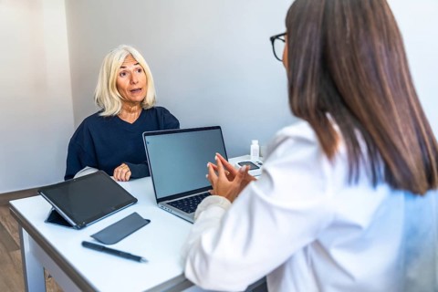 Senior woman is talking with a female doctor during a medical consultation in a modern office,