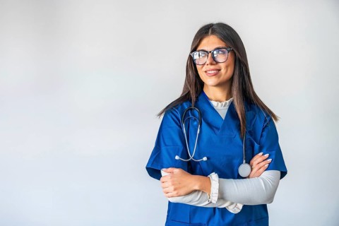 Young woman working as a professional healthcare provider, confidently standing with crossed arms,