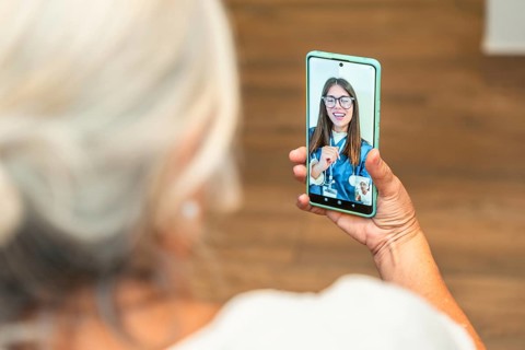 Senior woman is using a smartphone for an online medical consultation, receiving virtual healthcare