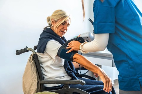 Medical professional monitoring the vital signs of an elderly patient with a blood pressure cuff