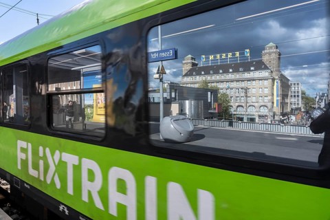 Flixtrain train on track 2 in Essen main station, reflection of the Handelshof building, city,