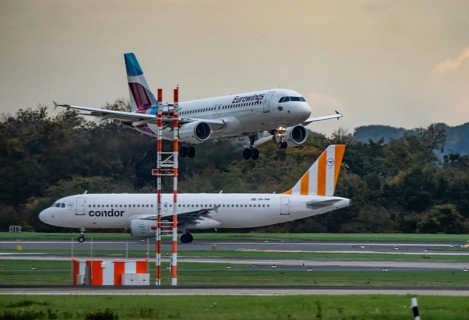 Eurowings Airbus landing at Düsseldorf airport, Condor Flieger waiting for takeoff, North