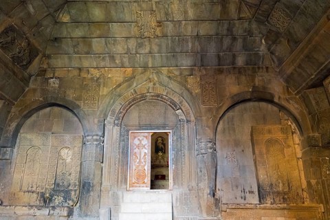 Detail of an ancient stone building with wall engravings and reliefs that conveys a historically