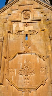 Detailed view of an artistic stone relief work with religious symbols on a church wall, Noravank