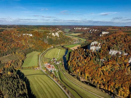 Aerial view of Upper Danube Valley surrounded by autumn vegetation, on the horizon Werenwag Castle,