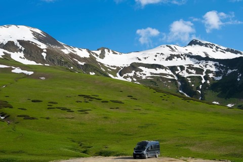 Snow and grassy hills stretch under a cloudy blue sky, Camper, Zagari Pass, Svaneti, Svaneti,