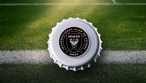 Bottle cap featuring the Inter Miami logo placed on a football field, symbolizing team loyalty and