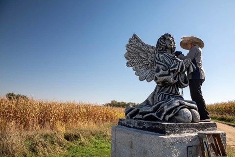 Chandler, Minnesota - Artist Primi Monteiga re-paints her concrete sculpture of an angel in the