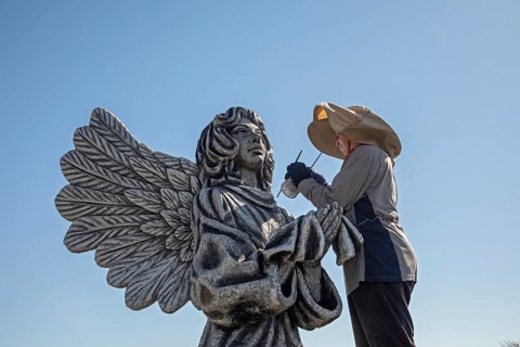 Chandler, Minnesota, Artist Primi Monteiga re-paints her concrete sculpture of an angel in the