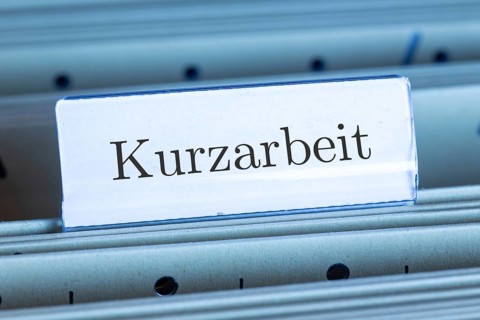 (photo montage) Sign with the inscription KURZARBEIT on a hanging file register