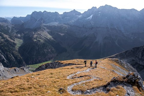Three hikers descending, hiking trail with serpentines from Gamsjoch, dramatic rock faces of