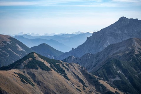 Mountain range with rolling hills and hazy sky, eastern Karwendel, Tyrol, Austria