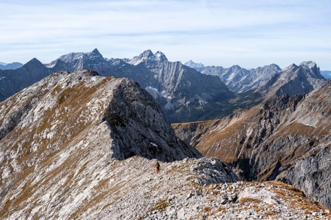 Hikers on the Gamsjoch ridge with a view of the vast mountain landscape, behind Dreizinkenspitze