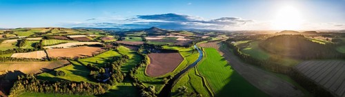 Panorama of evening Fields and Farms over River Teviot and Minto Crags from a drone, Roxburghshire,