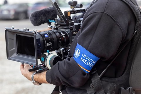 Cameraman at an event with the Federal Chancellor. The journalists wear an armband with the federal