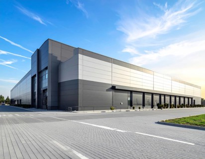 Modern supermarket building exterior against blue sky, Inviting white facade, some clouds, concept