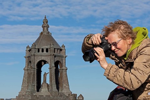 Woman photographing model, Kaiser Wilhelm Memorial, Porta Westfalica, North Rhine-Westphalia,