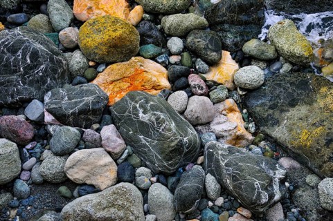 Colourful pebbles of various sizes with different patterns, on a beach in Liguria, Italy