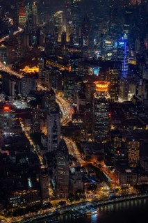 Aerial view over The Bund, Huangpu River waterfront and illuminated skyscrapers from the Shanghai