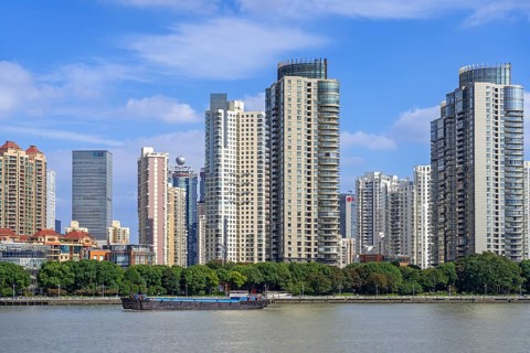 View over the Huangpu River and skyline showing skyscrapers and high-rise flats in the Pudong