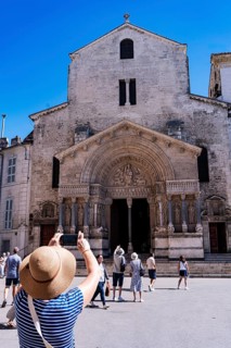Woman with sunhat photographs St. Trophime Cathedral, Arles, France